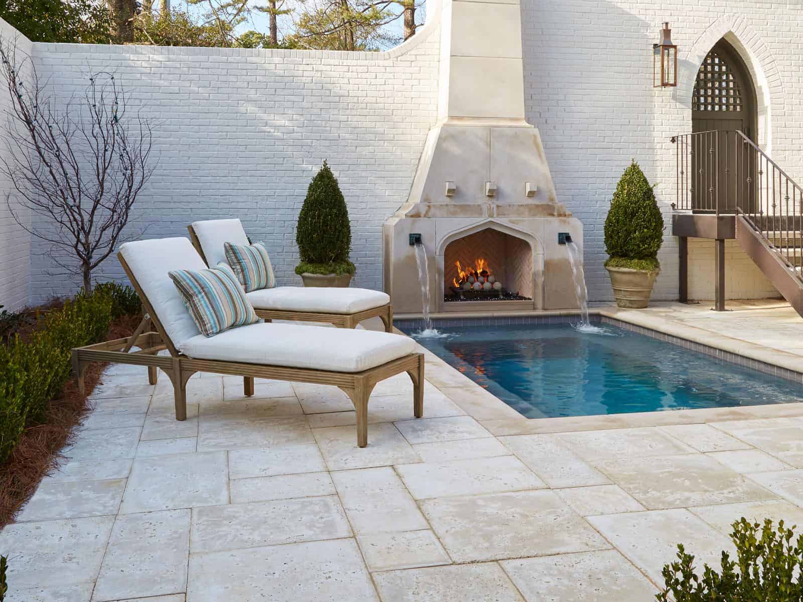 Peacock Pavers around an outdoor pool and fireplace, styled in a Basic Random Pattern.